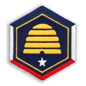 May include: A hexagonal embroidered patch with a yellow beehive design, a white star, and red, white, and blue borders.