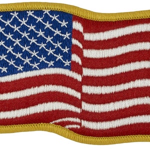 May include: A small, embroidered American flag patch with a gold border. The flag is waving slightly, and the stars and stripes are clearly visible.