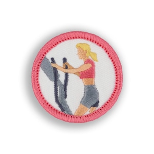 May include: A pink and white embroidered patch featuring a person exercising on a stationary elliptical machine.