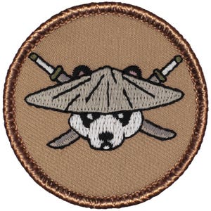 May include: A brown embroidered patch with a white panda wearing a brown hat and holding two swords crossed behind its head.