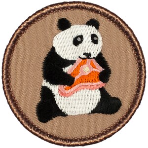 May include: A brown embroidered patch with a white and black panda bear holding a pink and orange object in its paws.