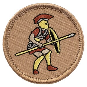 May include: A round, tan embroidered patch featuring a yellow and red illustration of a Roman soldier holding a spear and shield.