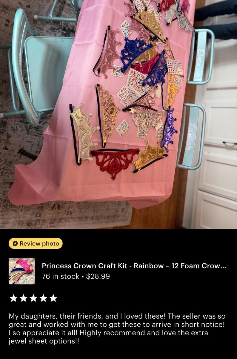 May include: A collection of colorful foam princess crowns in various designs, including gold, pink, blue, and red, are displayed on a pink surface. The crowns are embellished with glitter and decorative elements, perfect for craft projects.