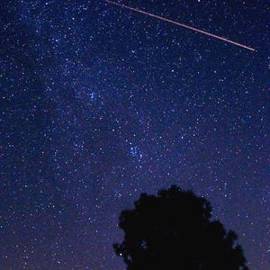 May include: Night sky photograph featuring a dark blue expanse of stars. A bright streak of light crosses the frame diagonally. A dark silhouette of a tree and a hill are in the foreground. The image is labeled with the text "&copy; 2018 La Renaissance Girl."