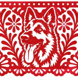 May include: A rectangular red paper cutout featuring a central illustration of a German Shepherd dog with its tongue out. The border is decorated with intricate floral patterns, leaves, and a series of small white circular cutouts along the edges.