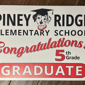 May include: A white sign with black and red text that reads "Piney Ridge Elementary School Congratulations! 5th Grade Graduate". A cartoon Dalmatian wearing a graduation cap is in the upper left corner of the sign.