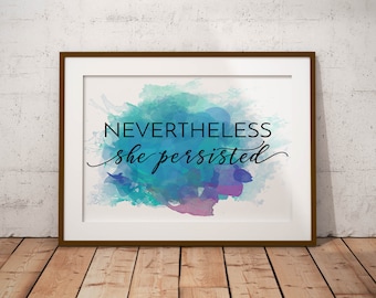 Puede incluir: Una impresión enmarcada con un fondo de acuarela en tonos azules, verdes y morados. El texto "NEVERTHELESS she persisted" está escrito en negro en la impresión.