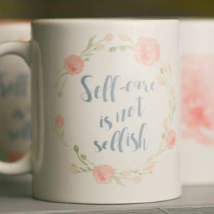 May include: White ceramic mug with a floral design and the text "Self-care is not selfish".