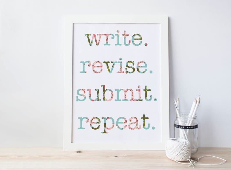K&ouml;nnte beinhalten: Wei&szlig;er gerahmter Druck mit dem Text "write. revise. submit. repeat." in einer floralen Schrift.