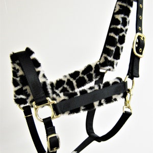 May include: Black nylon horse halter with a white and black leopard print fleece lining. The halter has gold metal hardware.