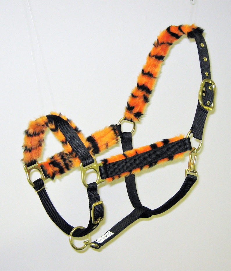May include: Black nylon horse halter with orange and black tiger print fur trim.