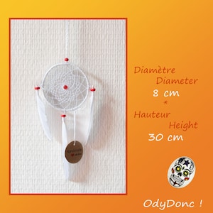 May include: White dream catcher with red beads and white feathers. The dream catcher is 8 cm in diameter and 30 cm tall. The tag says "Handmade with love".