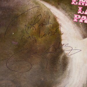 May include: A vintage album cover with a faded, textured appearance. The cover features a signature and the handwritten words "To and My Love". The upper right corner displays the text "EMERALD LAKE PALM".