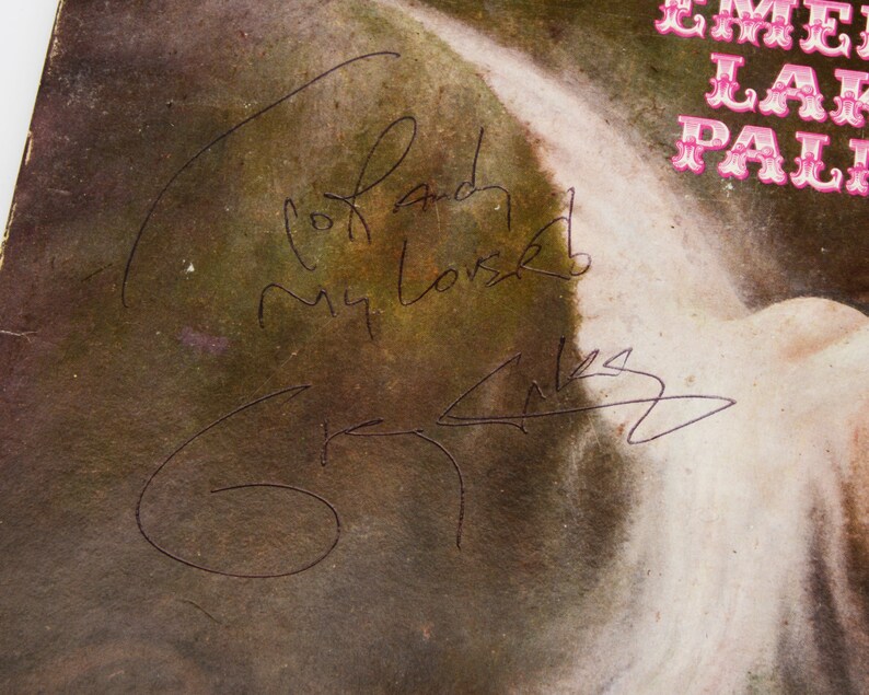 May include: A vintage album cover with a faded, textured appearance. The cover features a signature and the handwritten words "To and My Love". The upper right corner displays the text "EMERALD LAKE PALM".