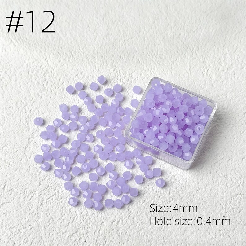 May include: A collection of faceted, light purple beads, scattered on a white surface, with some contained in a clear square container. The text "#12" is in the upper left corner. The text "Size: 4mm" and "Hole size: 0.4mm" are in the lower right corner.