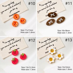 May include: A collection of decorative buttons in various shapes and designs. Includes orange polka dot buttons, brown oval buttons with bow details, red strawberry buttons, and white daisy buttons. Each set is displayed with a tag that has text.