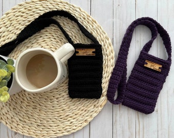 May include: Two rectangular crochet pouches with long straps, one in black and one in deep purple. Each pouch features a horizontal ribbed texture and a small, rectangular wooden tag attached to the front with the text "handmade with love" and "pdl".