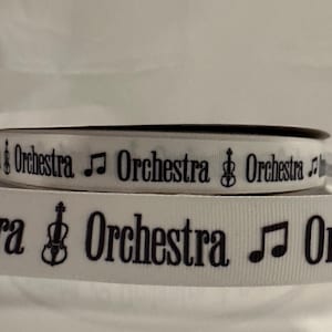 May include: White ribbon with black text and symbols. The text reads "Orchestra" and the symbols are a musical note and a violin.