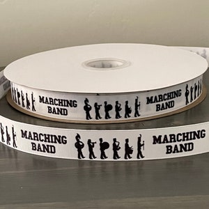 May include: White ribbon with black silhouettes of marching band members and the text "Marching Band" repeated on the ribbon.
