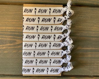 May include: A set of eight white elastic hair ties with the word "RUN" and a running figure printed on each tie.