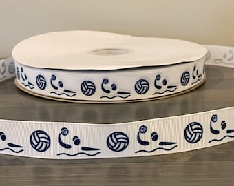 May include: White ribbon with a repeating pattern of blue water polo players and balls. The ribbon is rolled up on a white spool.