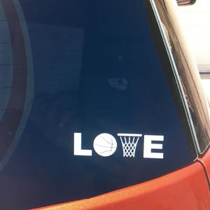 May include: A white vinyl decal with the word "LOVE" with a basketball and a basketball hoop replacing the "O".
