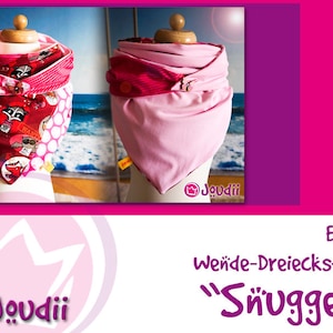 May include: Two reversible triangle scarves displayed on mannequin heads. One scarf features a red raccoon print, the other is solid pink. The scarves are designed with a layered, cozy appearance. The image includes the text "Joudii" and "Snüggel".
