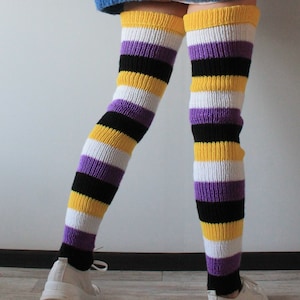 Peut inclure: Chaussettes hautes à rayures jaunes, blanches, violettes et noires. Les chaussettes sont portées avec des baskets blanches. Les chaussettes sont en matière tricotée.