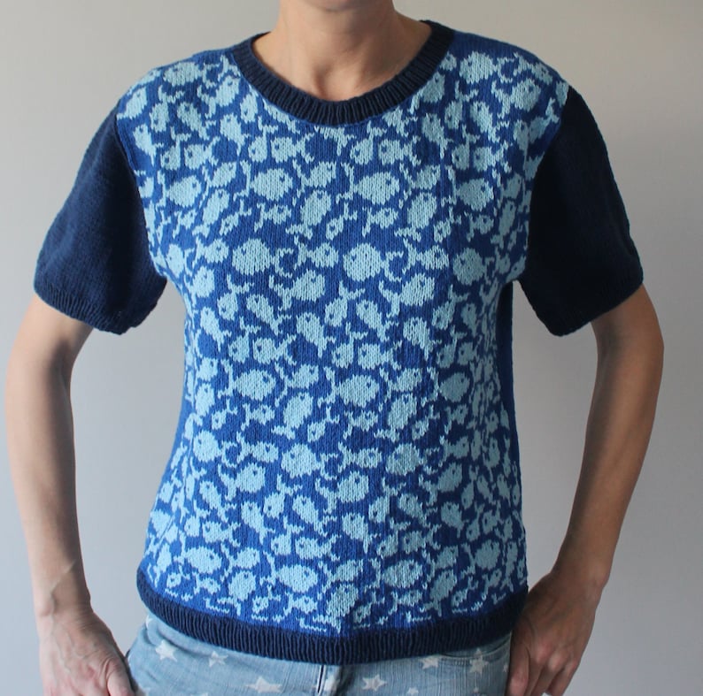May include: A blue and light blue knit short-sleeved sweater with a fish pattern.