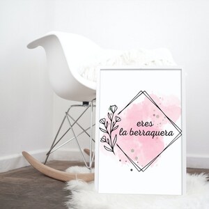 May include: A pink watercolor print with a black outline of a diamond shape. The text "eres la berraquera" is inside the diamond shape.