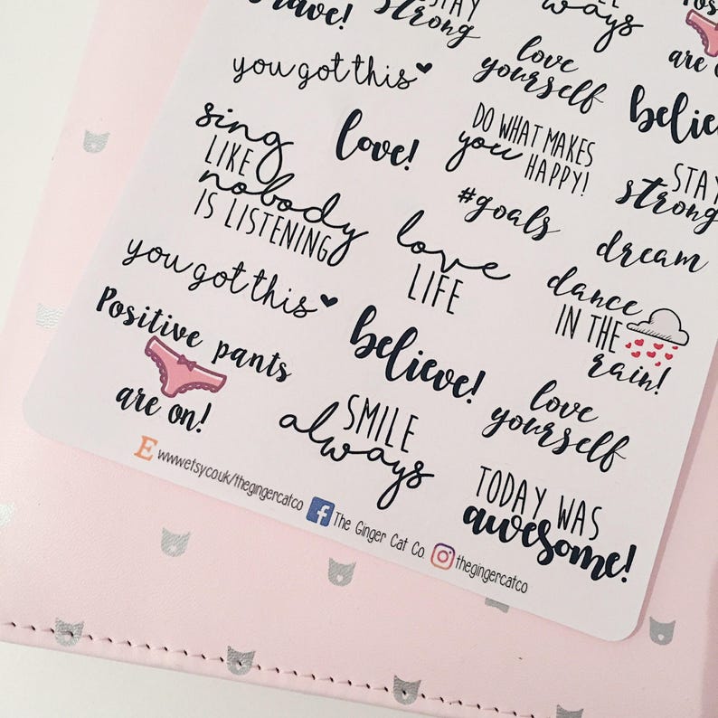 May include: A sheet of white stickers with black and pink lettering. The stickers feature positive affirmations and motivational quotes such as "love yourself", "believe", "smile always", "you got this", "dance in the rain", and "positive pants are on!"