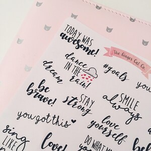 May include: A set of pink and white motivational stickers with handwritten text, including "Today was awesome!" "Dance in the rain!" "Be brave!" "Stay strong!" "You got this!" "Smile always" "Love yourself" "#goals" and "Do what you love".