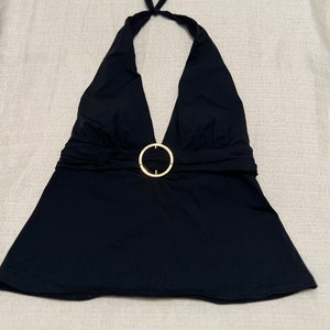 May include: Black halter top with a gold ring accent at the waist.