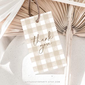 May include: A brown and white gingham thank you tag with the words "thank you" written in brown cursive script.