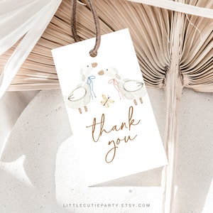 May include: A white thank you tag with a watercolor illustration of two birds with blue and pink ribbons and a yellow butterfly. The text "thank you" is written in brown cursive.