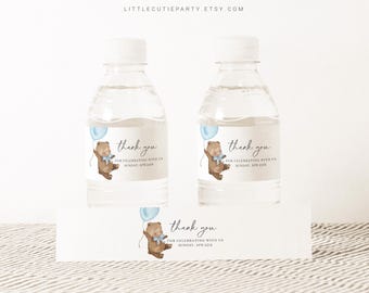 May include: Water bottle labels with a brown bear holding a blue balloon. The labels say "thank you for celebrating with us" and include a date.