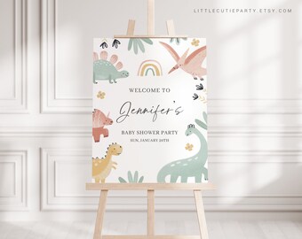 May include: Welcome to Jennifer's Baby Shower Party, Sun. January 20th. A white sign with a rainbow, green and pink dinosaurs, and floral accents.