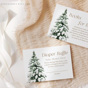 May include: Two white cards with a watercolor illustration of a snow-covered evergreen tree. One card reads "Books for Baby" and the other says "Diaper Raffle" for a baby shower. The Etsy shop name is in the top left corner.
