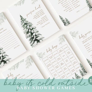 May include: A collection of baby shower games with a winter theme. The cards feature illustrations of snow-covered pine trees and include games like "Pacifier Hunt" and "Baby Bingo." The phrase "baby it's cold outside" is written at the bottom.
