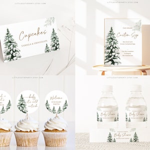 May include: A collection of winter-themed baby shower decorations. Includes a table card with "Cupcakes" and "Vanilla & Chocolate" text, cupcake toppers, water bottle labels, and a sign with "Custom Size" text. All feature evergreen tree illustrations.