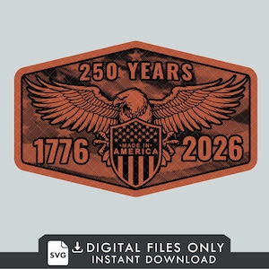 May include: A brown and black graphic design featuring an eagle with outstretched wings, a shield, and the text "250 YEARS 1776 2026 MADE IN AMERICA". The design is in a shield shape with a star at the top.