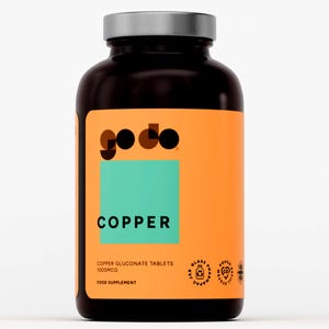 Op de afbeelding: Een donkerbruine fles met een zilveren deksel en een oranje etiket. Het etiket toont het woord "COPPER" in het wit, boven de tekst "COPPER GLUCONATE TABLETS 1000MCG" en het merk "godo". De fles bevat een voedingssupplement.