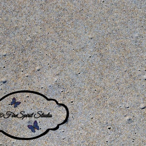 May include: A close-up of a gray, sandy beach with a black oval-shaped graphic with the text "Fire Spirit Studio" and two purple butterflies.