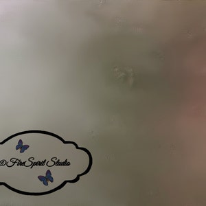 Può includere: Uno sfondo astratto con una sfumatura di colori, tra cui grigio, rosa e beige. Una cornice nera a forma di nuvola contiene il testo "©Fire Spirit Studio" e due farfalle blu.