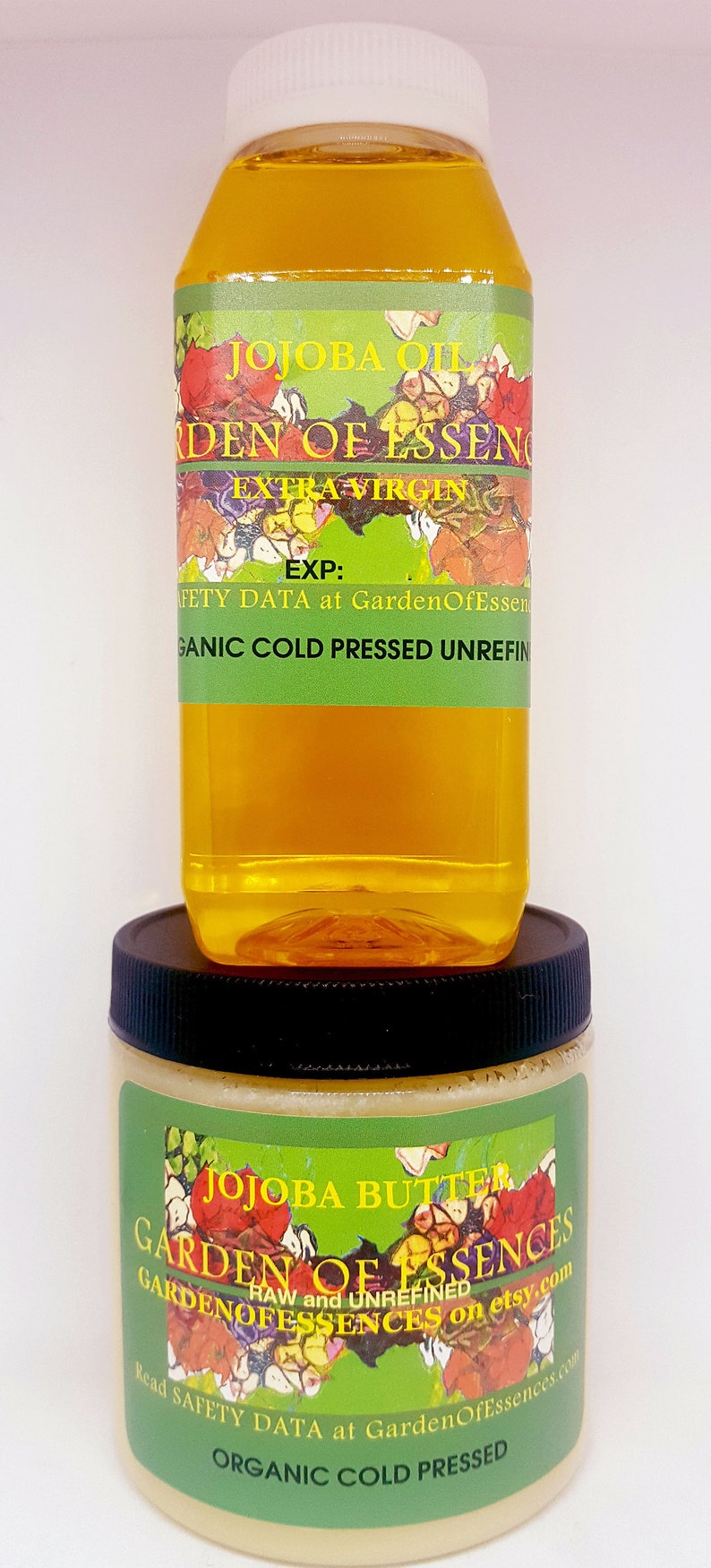 May include: Two bottles of organic cold-pressed jojoba oil and butter from Garden of Essences. The jojoba oil bottle is clear with a yellow liquid and a green label with the text "Jojoba Oil Garden of Essences Extra Virgin EXP: Safety Data at GardenOfEssences Organic Cold Pressed Unrefined". The jojoba butter jar is white with a green label with the text "Jojoba Butter Garden of Essences RAW and UNREFINED GARDENOFESSENCES on etsy.com Read Safety Data at GardenOfEssences.com ORGANIC COLD PRESSED".