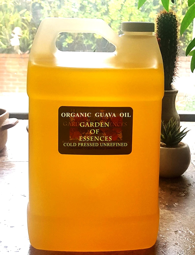 May include: A large, translucent yellow plastic jug filled with organic guava oil. The jug has a handle and a gray cap. A label on the front reads "Organic Guava Oil" and "Cold Pressed Unrefined."