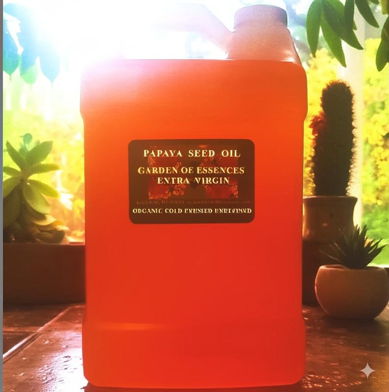 K&ouml;nnte beinhalten: Ein gro&szlig;er, durchscheinender orangefarbener Kunststoffkanister mit Fl&uuml;ssigkeit und einem schwarzen rechteckigen Etikett, das die Aufschrift PAPAYA SEED OIL, GARDEN OF ESSENCES, EXTRA VIRGIN und ORGANIC COLD PRESSED UNREFINED in Gold tr&auml;gt.