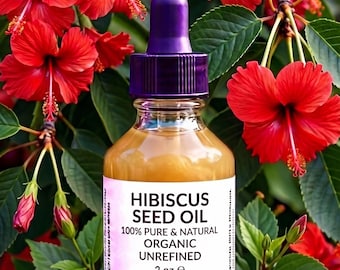 May include: A clear glass bottle of Hibiscus Seed Oil with a purple dropper top. The label reads "100% Pure & Natural Organic Unrefined 2 oz e". The bottle is surrounded by red hibiscus flowers and seeds.