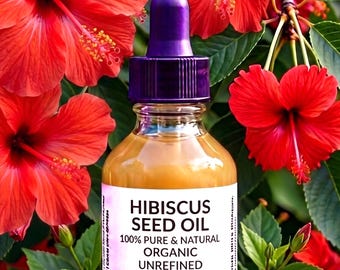 May include: A clear glass bottle of Hibiscus Seed Oil with a purple dropper top. The label reads "HIBISCUS SEED OIL 100% PURE & NATURAL ORGANIC UNREFINED 2 oz e Garden of Essences". The bottle is surrounded by red hibiscus flowers and green leaves.