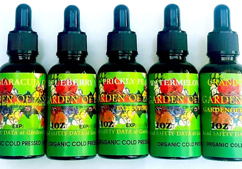 May include: Five 1 oz bottles of organic cold-pressed oil. The bottles are labeled with different fruit names: Maracuja, Blueberry, Prickly Pear, Watermelon, and Cranberry. Each bottle has a dropper top.